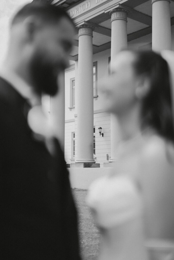 Brautpaar in Schwarz-Weiß vor einer Säulenfassade – Hochzeitsfotograf erweddingphoto